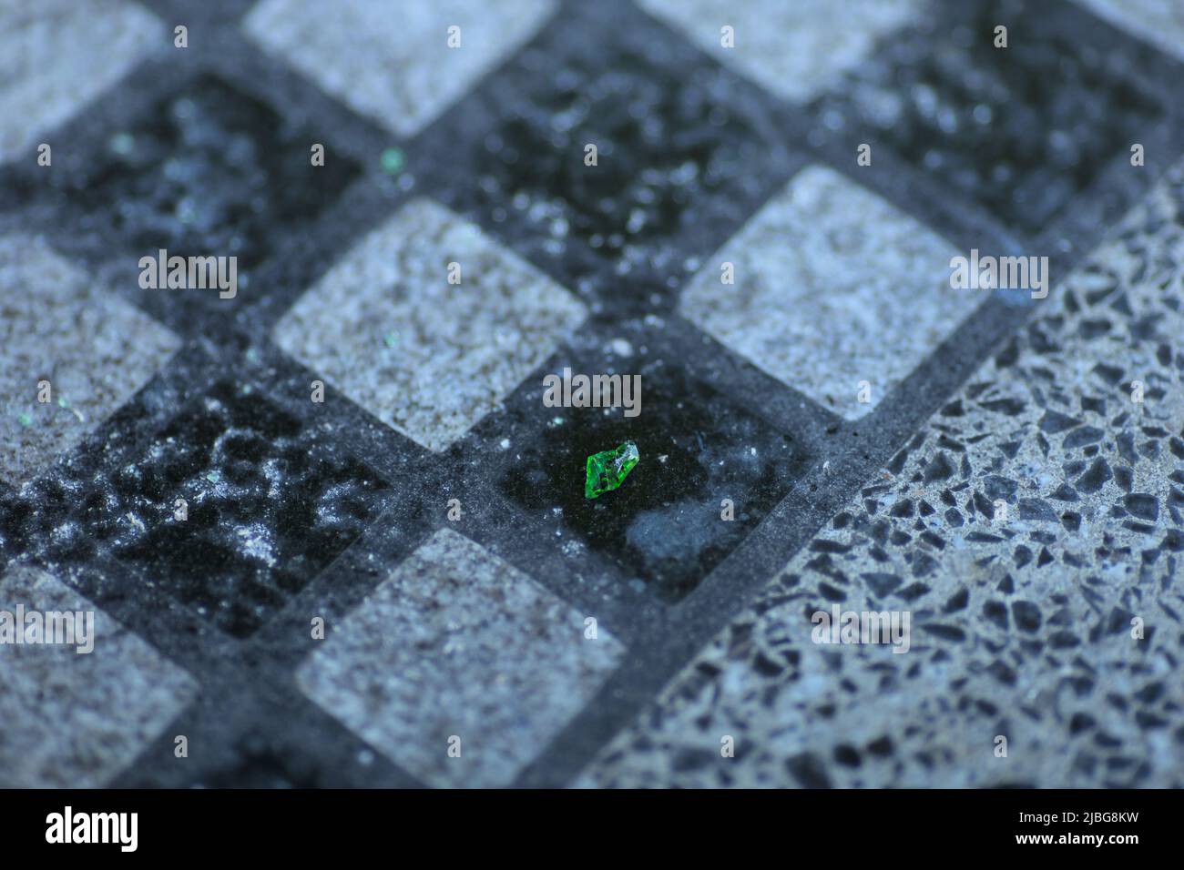 Un morceau de verre vert sur un échiquier en granit dans un parc Banque D'Images