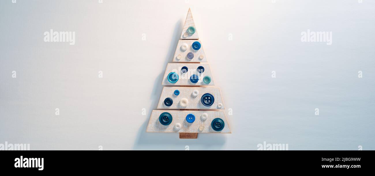 Petit joli arbre de Noël en bois sur fond blanc Banque D'Images