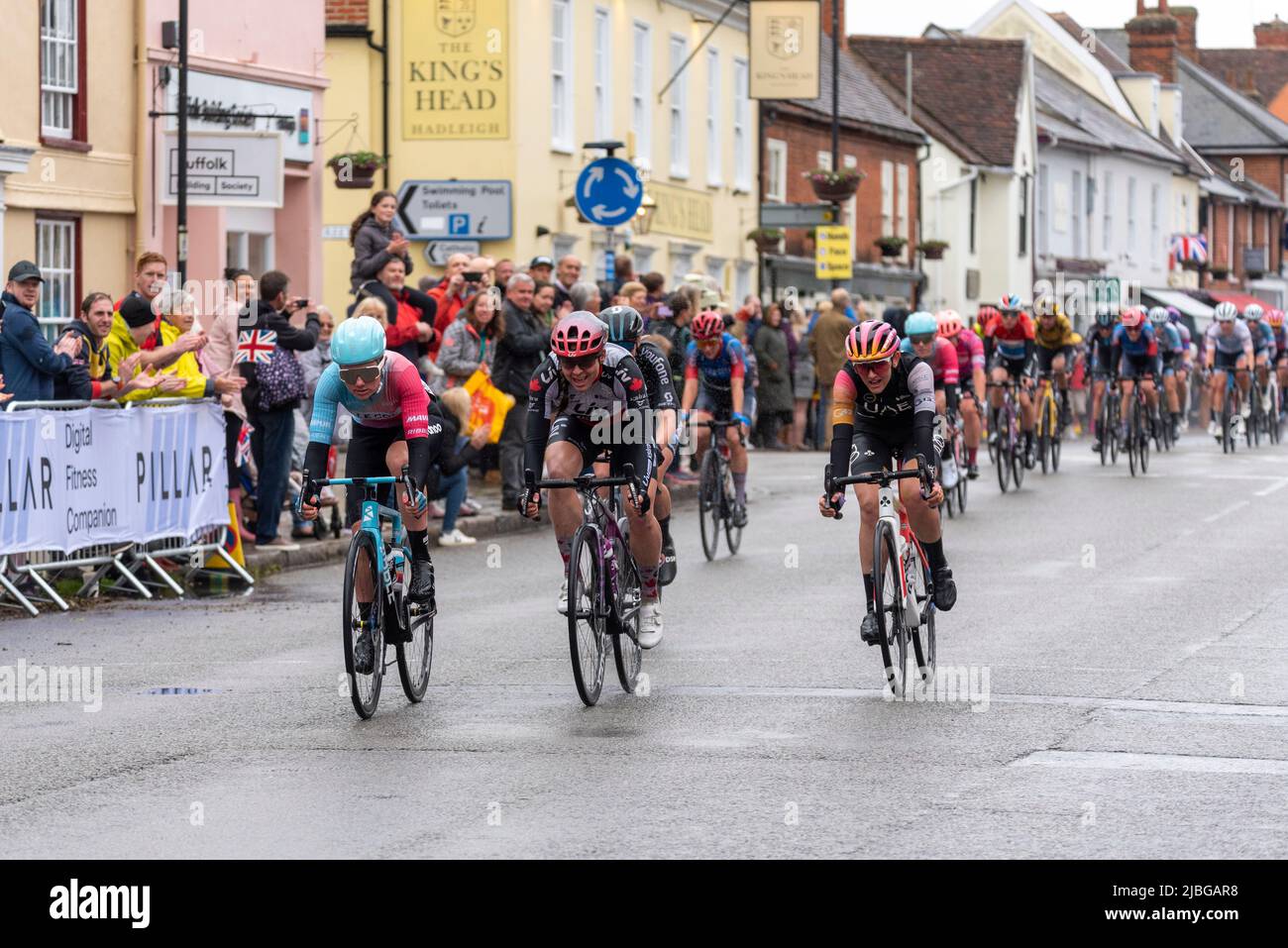 High Street, Hadleigh, Suffolk, Royaume-Uni. 6th juin 2022. La course cycliste UCI Women’s Tour a commencé avec les meilleurs pilotes du monde au départ de Colchester pour la phase 1 142km à travers la campagne Essex et Suffolk jusqu’à la fin à Bury St. Edmunds. Une section de sprint s'est terminée dans la haute rue d'Hadleigh sous la pluie, gagnée par Maike van der Duin du Col Wahoo (à gauche), devant Alison Jackson et Laura Tomasi. Des spectateurs ont bordé la rue pour encourager les cavaliers à travers la ville Banque D'Images High Street, Hadleigh, Suffolk, Royaume-Uni. 6th juin 2022. La course cycliste UCI Women’s Tour a commencé avec les meilleurs pilotes du monde au départ de Colchester pour la phase 1 142km à travers la campagne Essex et Suffolk jusqu’à la fin à Bury St. Edmunds. Une section de sprint s'est terminée dans la haute rue d'Hadleigh sous la pluie, gagnée par Maike van der Duin du Col Wahoo (à gauche), devant Alison Jackson et Laura Tomasi. Des spectateurs ont bordé la rue pour encourager les cavaliers à travers la ville Banque D'Images