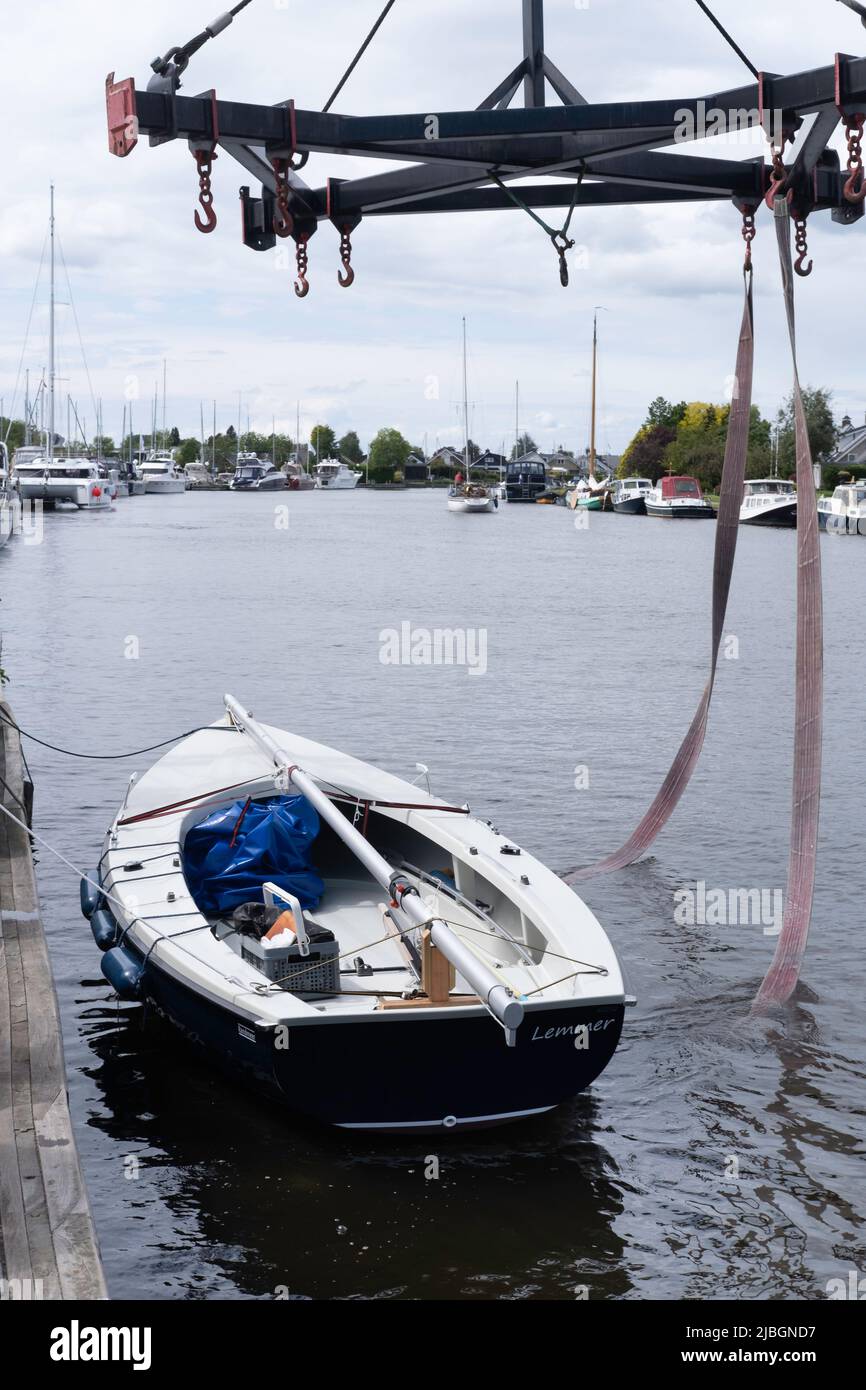 Le Voilier vient d'être soulevé de la jetée dans l'eau par une grue. Les pneus qui se trouvaient sous le navire sont suspendus dans l'eau Banque D'Images