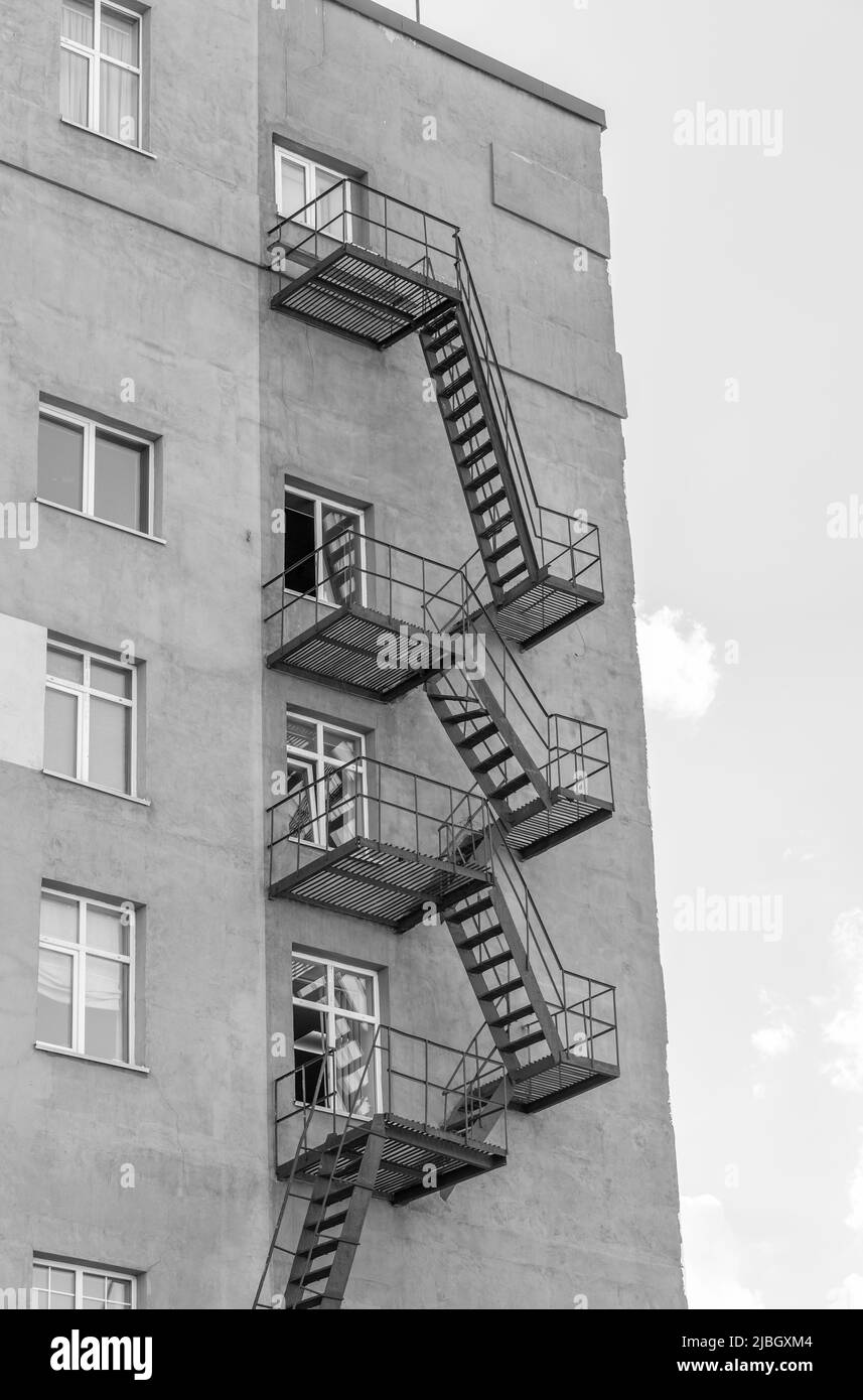 Silhouette d'une évasion de feu sur un bâtiment de haute élévation contre un ciel bleu avec des nuages. Certains escaliers sont cassés. Il y a de l'espace libre pour le texte. Noir Banque D'Images