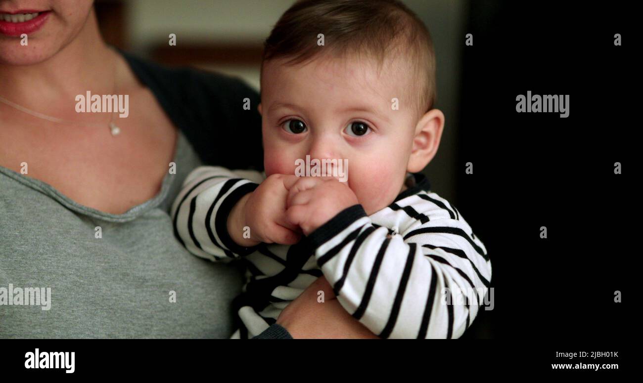 Mère tenant bébé à l'intérieur en parlant. Un parent tient un bébé tout-petit Banque D'Images