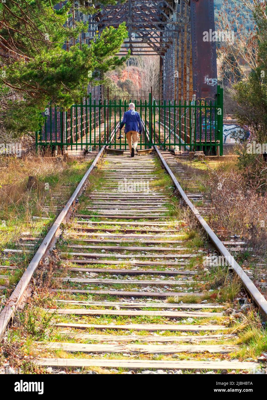 Un homme en face d'un pont ferroviaire abandonné construit au-dessus de la rivière Duero en passant par Soria. Banque D'Images