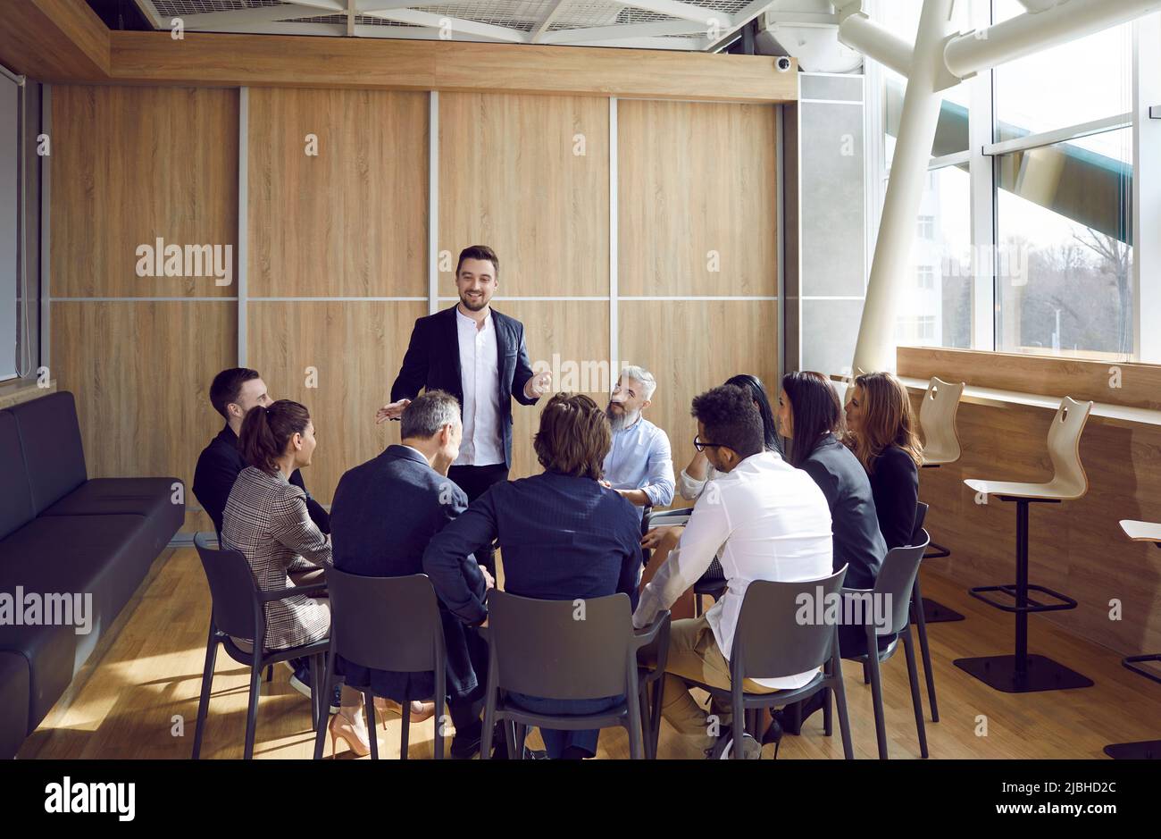 Équipe de personnes assises au bureau, se rencontrant avec un coach d'affaires et écoutant son discours Banque D'Images