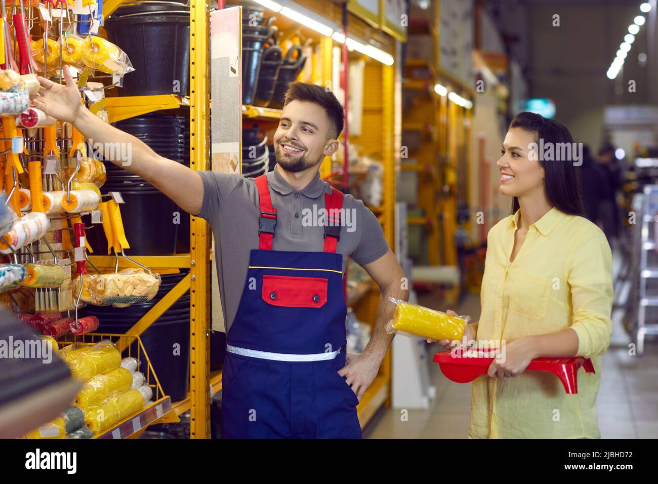 Une bonne cashale féminine dans le magasin de matériaux de construction choisit des outils pour faire des réparations à la maison. Banque D'Images