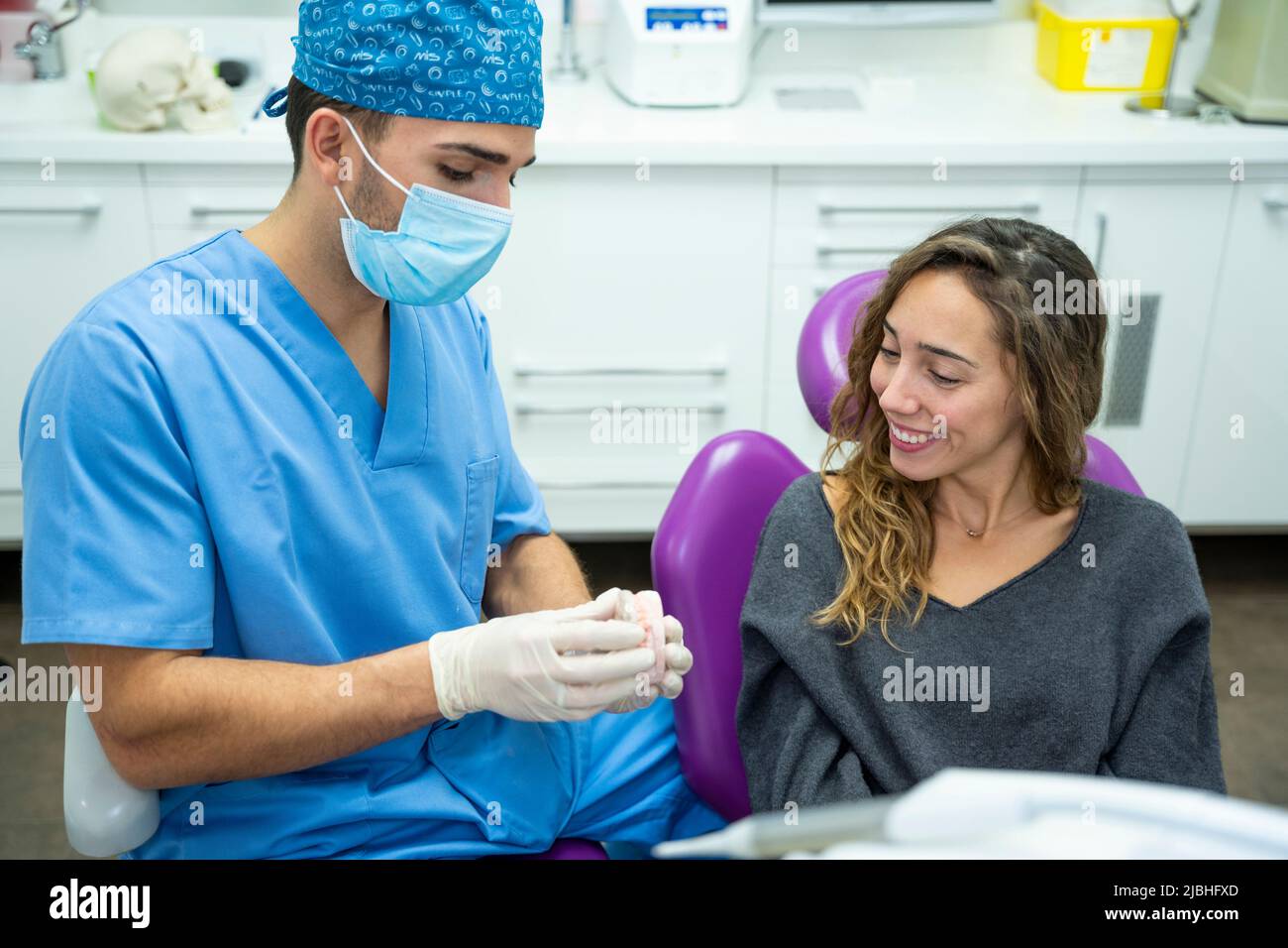 Dentiste montrant une intervention à une jeune patiente Banque D'Images