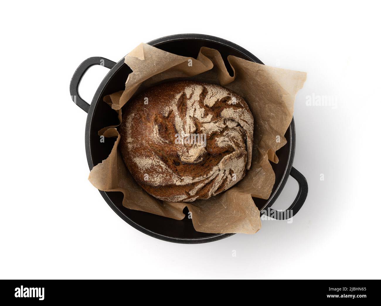 pain de seigle traditionnel fraîchement cuit maison isolé dans une casserole en métal foncé avec papier pergament isolé sur fond blanc, vue de dessus, pain entier rond Banque D'Images