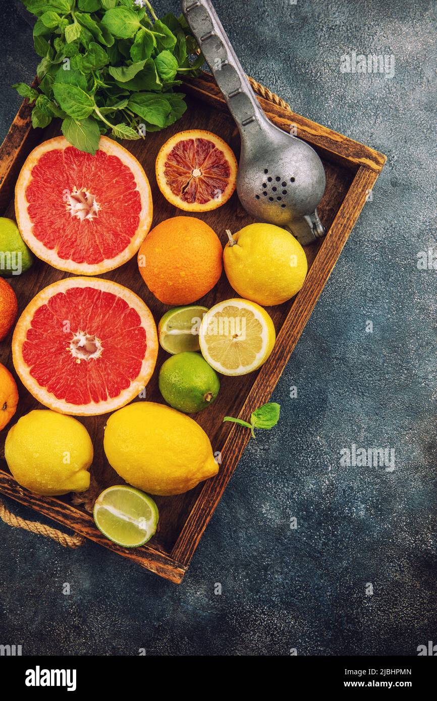 Agrumes tropicaux frais orange pamplemousse citron citron lime sur fond sombre Banque D'Images