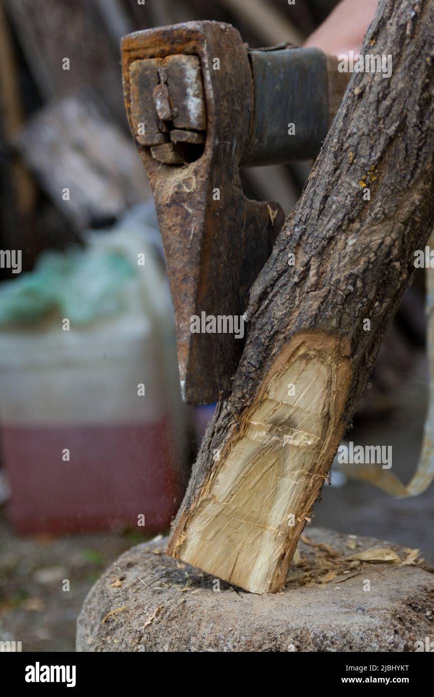 Processus d'aiguisage de bâton de bois avec une hache extérieure dans un jardin. Gros plan, mise au point sélective Banque D'Images