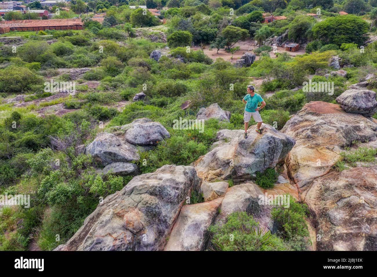 Vue aérienne d'un homme se tenant au sommet d'un plateau rocheux à Tobati, Paraguay. Banque D'Images