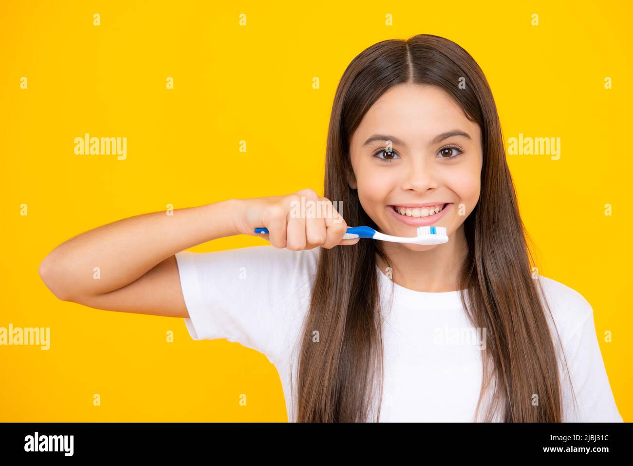 Joyeux portrait d'adolescent. Une adolescente se brossant les dents sur un fond jaune isolé. Brosse à dents d'hygiène quotidienne pour adolescents, routine du matin Banque D'Images