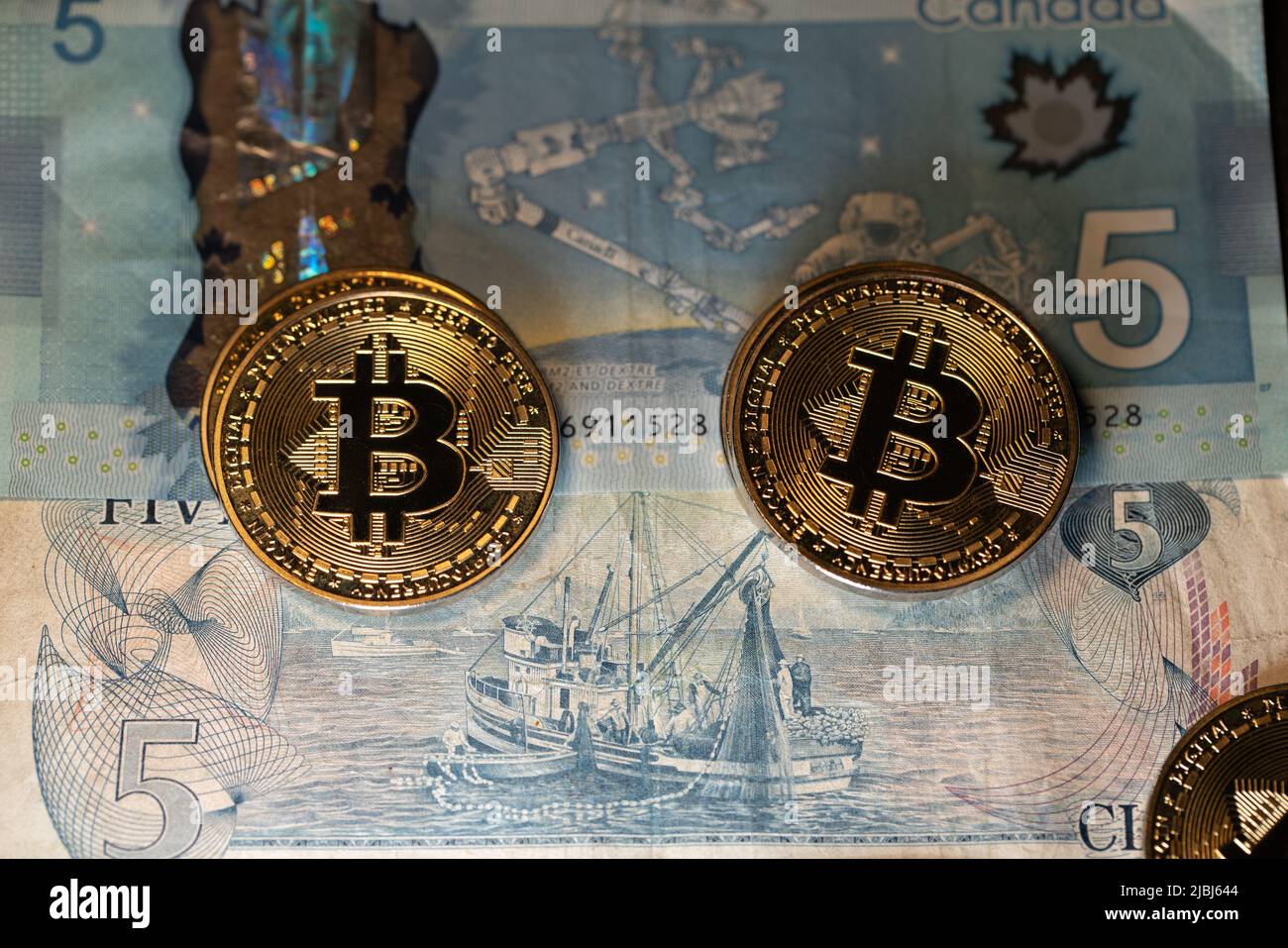 Toronto, Canada - 30 octobre. 2021: Pièces en bitcoin sur les billets en dollars canadiens, commerce de BTC avec CAD Banque D'Images