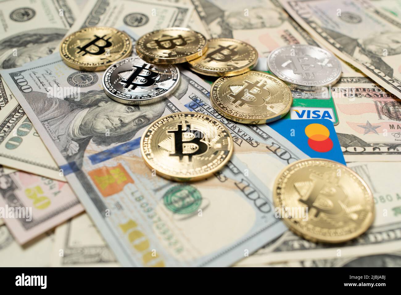 Bolzano, Italie - 26 mars 2021 : bitcoin sur les billets en dollars et les cartes de crédit. Paiement en devise Crypto avec Visa et Mastercard. Argent numérique avec papier c Banque D'Images