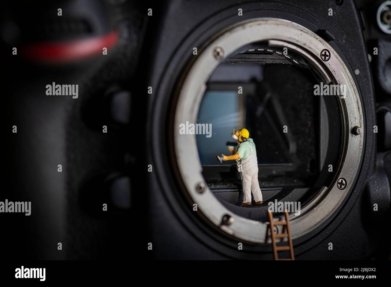 Miniature personnes petit modèle humain nettoyage appareil photo reflex numérique miror Banque D'Images