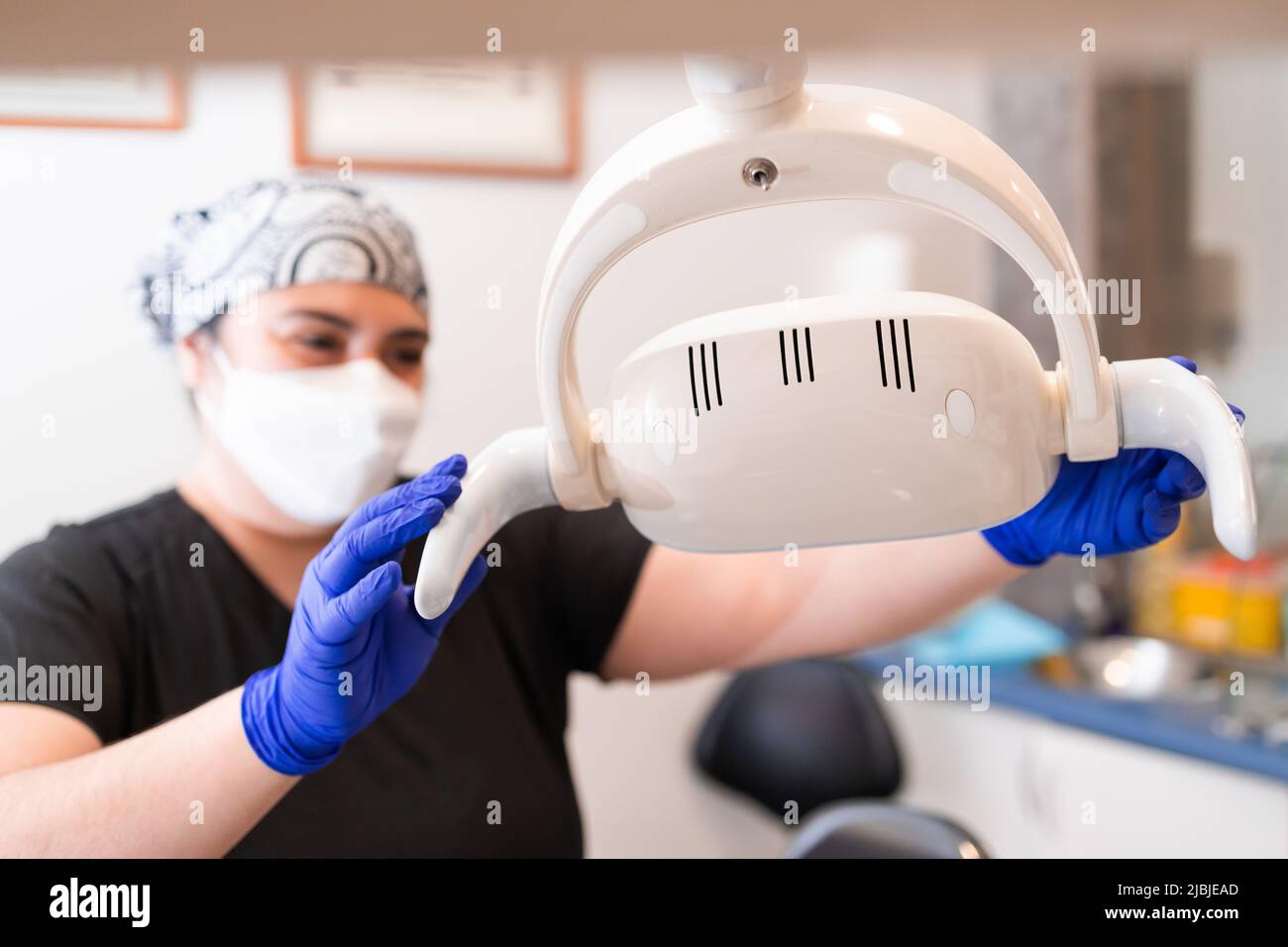 Femme dentiste préparant la lumière de chaise dentaire. Mise au point sélective Banque D'Images