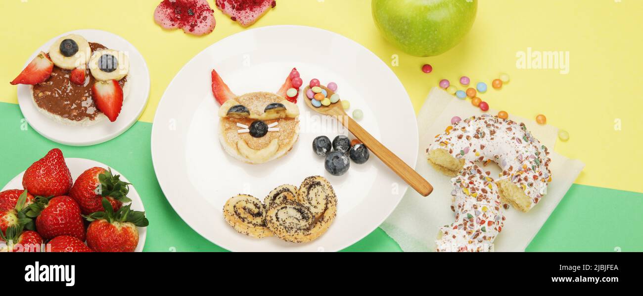 Des toasts sains pour les enfants sur fond coloré. Idée de petit déjeuner sain. Déjeuner ludique. Vue de dessus, plan d'affichage, espace de copie, panorama Banque D'Images