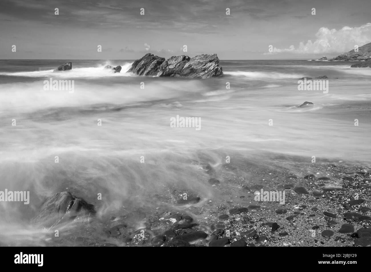 Image d'exposition longue des vagues qui se brisent sur les rochers de la côte nord de Cornouailles Banque D'Images