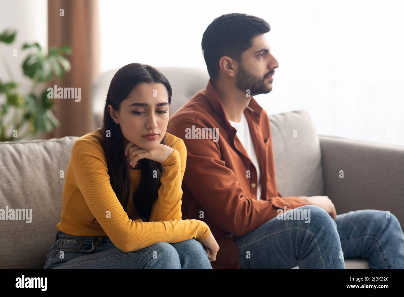 Malheureux couple arabe assis sur le canapé intérieur, ayant des problèmes de relation Banque D'Images