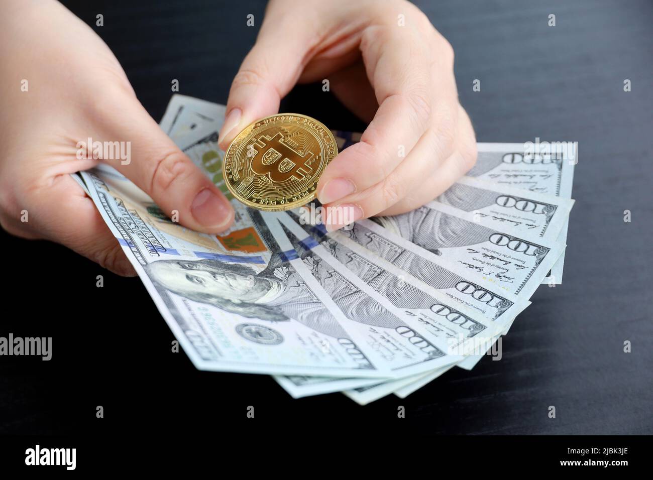 Bitcoin et billets en dollars américains entre les mains des femmes. Monnaie électronique décentralisée, taux de change et croissance de la crypto-monnaie Banque D'Images