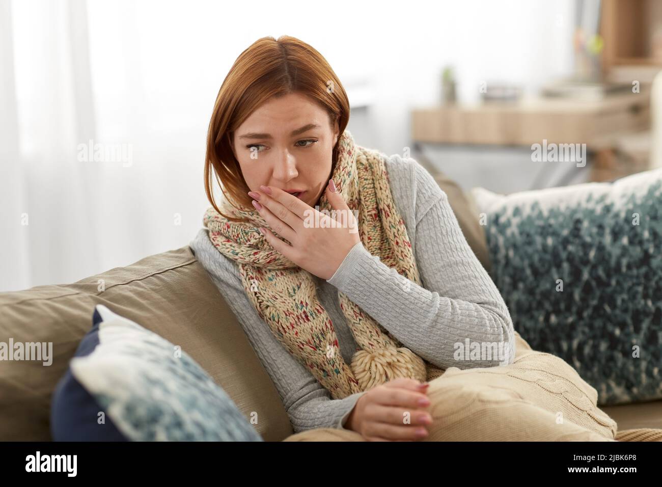 femme malade dans le foulard toussant à la maison Banque D'Images
