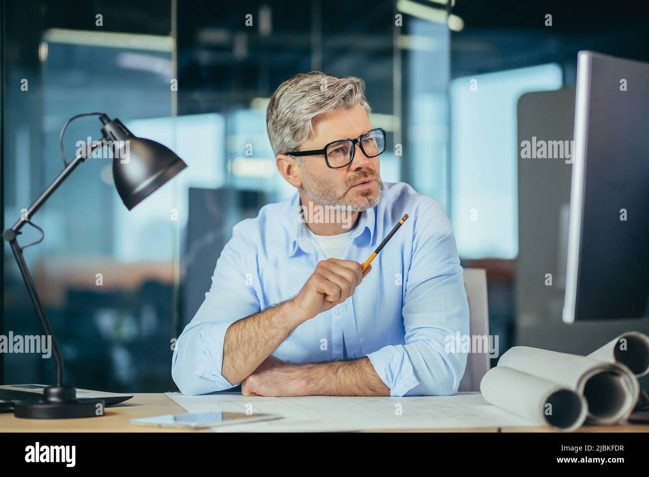 Architecte concepteur expérimenté travaille à la table dessine un projet de plan de la maison, un homme regarde le moniteur, un homme au travail Banque D'Images