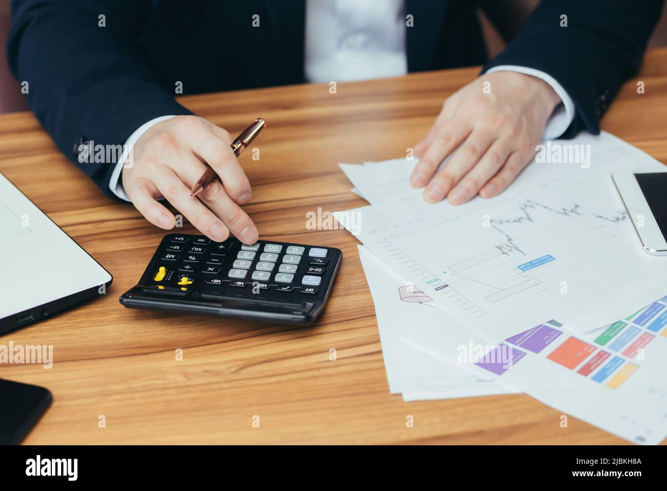 Gros plan des mains d'un jeune homme comptable, homme d'affaires, directeur travaille avec des documents, compte sur une calculatrice, écrit des factures dans le bureau de la Banque D'Images