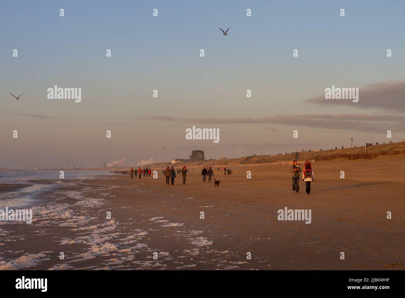 Les gens qui marchent sur la plage de Zandvoort à l'heure du coucher du soleil, Hollande Banque D'Images