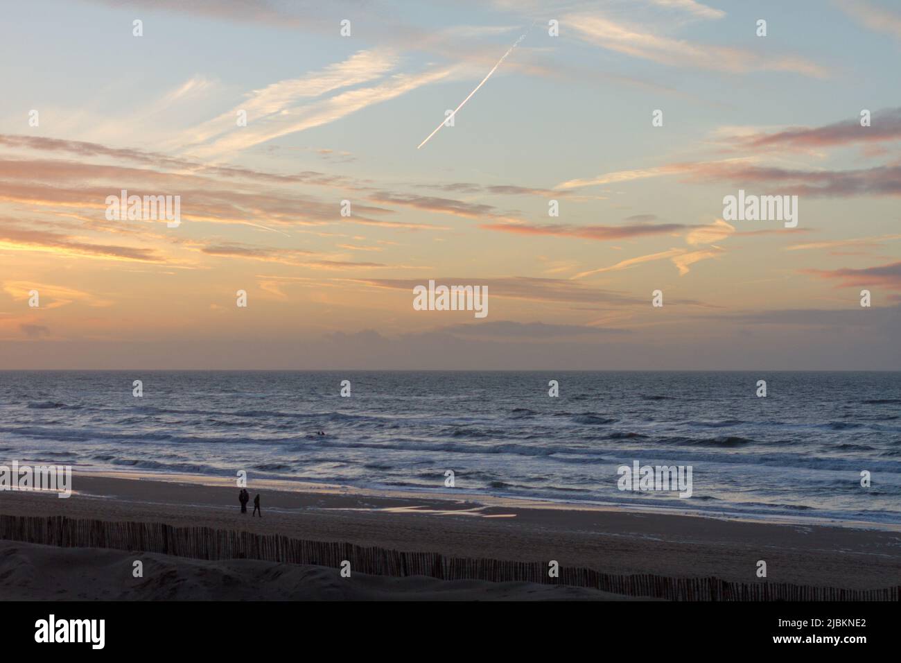 Les gens qui marchent sur la plage de Zandvoort à l'heure du coucher du soleil, Hollande Banque D'Images