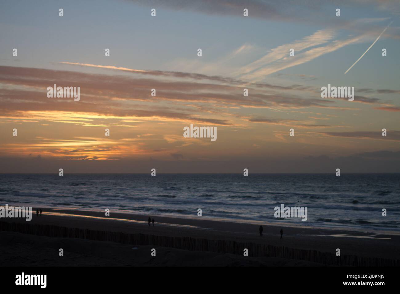 Les gens qui marchent sur la plage de Zandvoort à l'heure du coucher du soleil, Hollande Banque D'Images