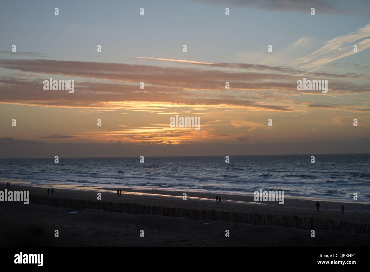 Les gens qui marchent sur la plage de Zandvoort à l'heure du coucher du soleil, Hollande Banque D'Images