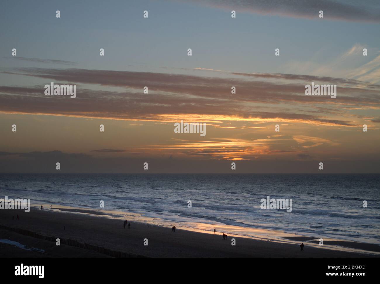 Les gens qui marchent sur la plage de Zandvoort à l'heure du coucher du soleil, Hollande Banque D'Images