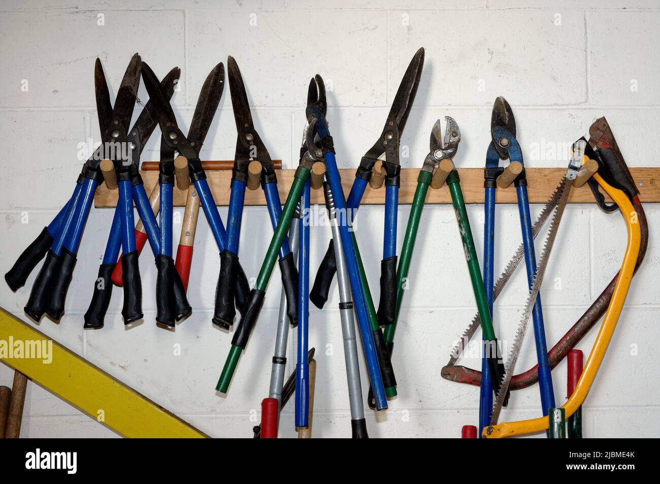 Une collection d'outils de jardinage accrochés à un mur Banque D'Images
