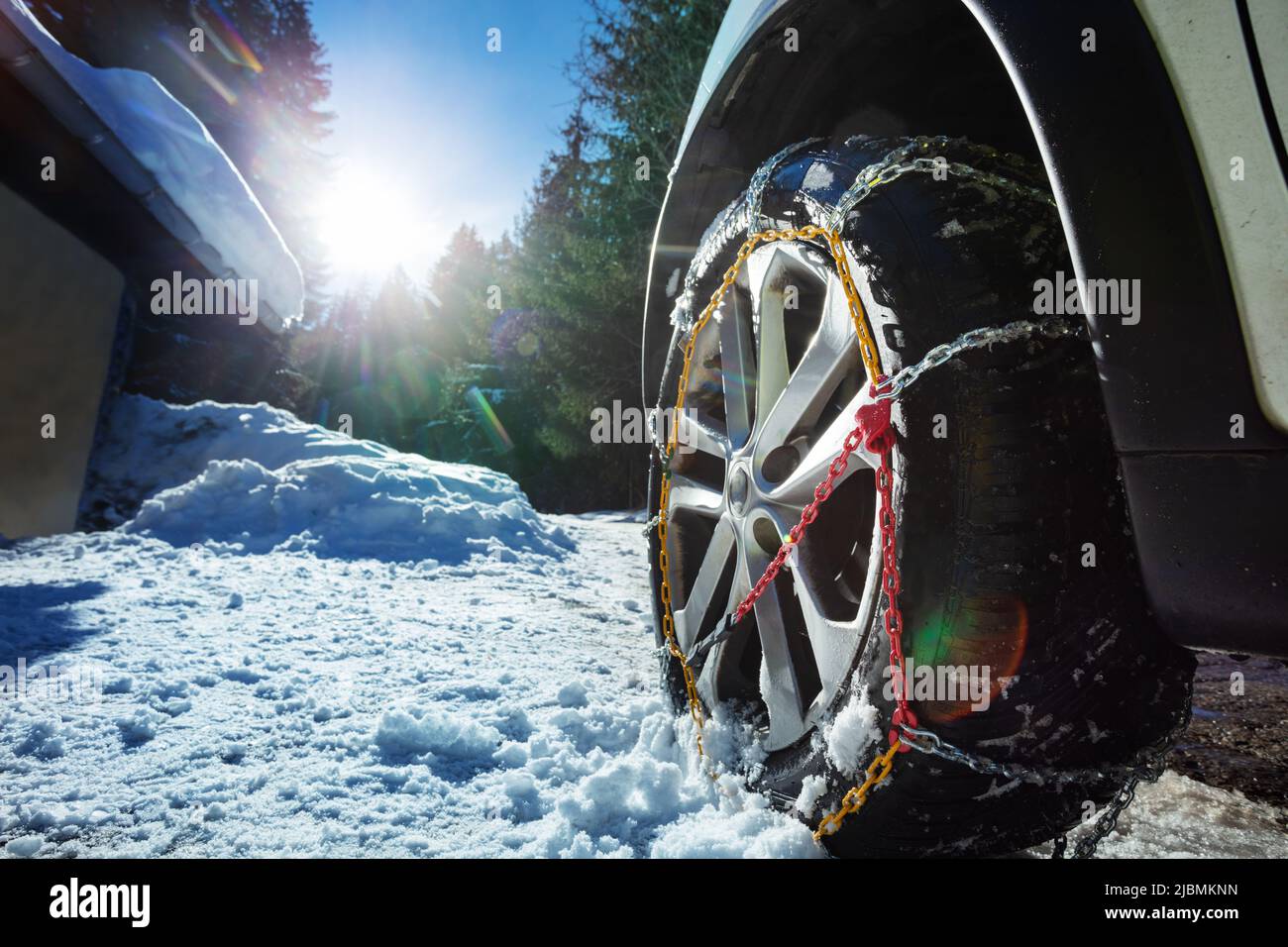 Roue de voiture avec chaînes d'hiver pour la chaussée glacée sur fond  ensoleillé Photo Stock - Alamy