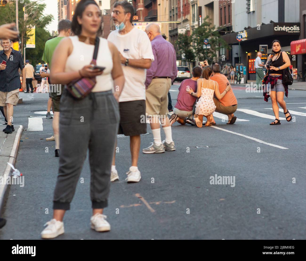 Les photographes risquent leur vie et leur jambe lorsqu'ils se trouvent dans West 23rd Street à Chelsea, à New York, pour photographier le coucher du soleil de Manhattatanhenge lundi, 30 mai 2022. Deux fois par an, le soleil se couche au coucher du soleil avec la grille de la ville et se coucher au milieu des routes. L'événement, le nom inventé par Neil deGrasse Tyson du planétarium Hayden, a lieu 22 jours avant et 21 jours après le solstice d'été en raison de l'angle de 30 degrés de la grille de la ville, il n'est pas exactement est-ouest-nord-sud. (© Richard B. Levine Banque D'Images