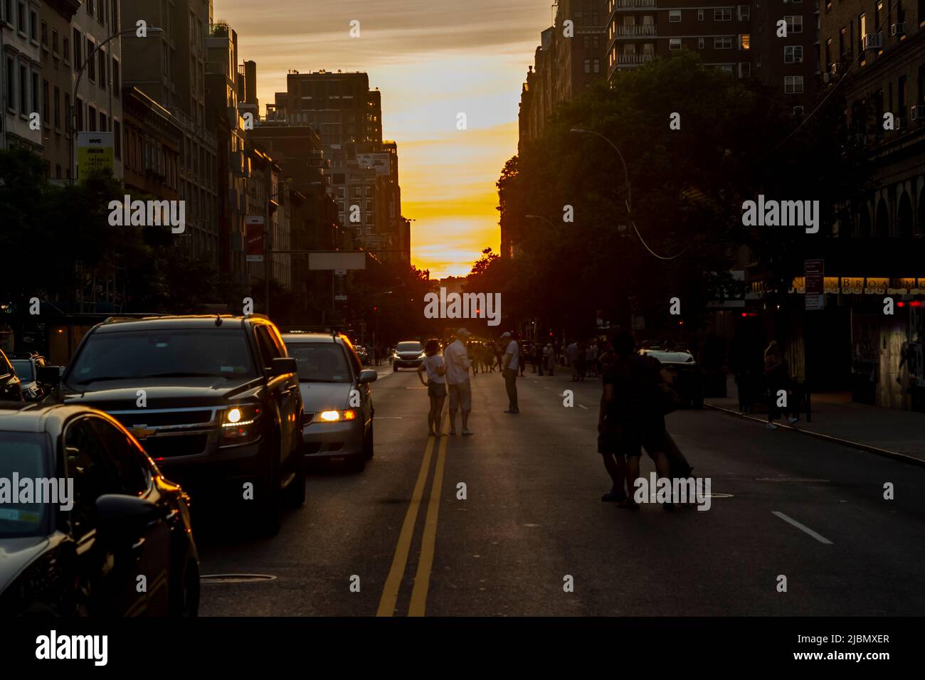 Les photographes risquent leur vie et leur jambe lorsqu'ils se trouvent dans West 23rd Street à Chelsea, à New York, pour photographier le coucher du soleil de Manhattatanhenge lundi, 30 mai 2022. Deux fois par an, le soleil se couche au coucher du soleil avec la grille de la ville et se coucher au milieu des routes. L'événement, le nom inventé par Neil deGrasse Tyson du planétarium Hayden, a lieu 22 jours avant et 21 jours après le solstice d'été en raison de l'angle de 30 degrés de la grille de la ville, il n'est pas exactement est-ouest-nord-sud. (© Richard B. Levine Banque D'Images