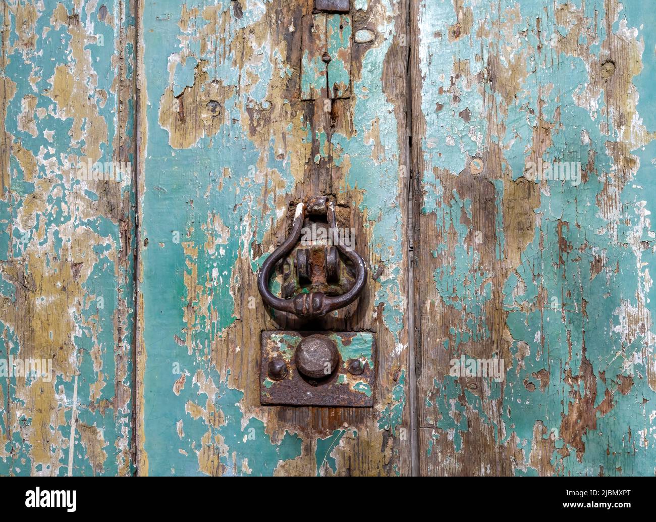Ancienne porte en bois délabrée, avec porte en fer et peinture verte Banque D'Images