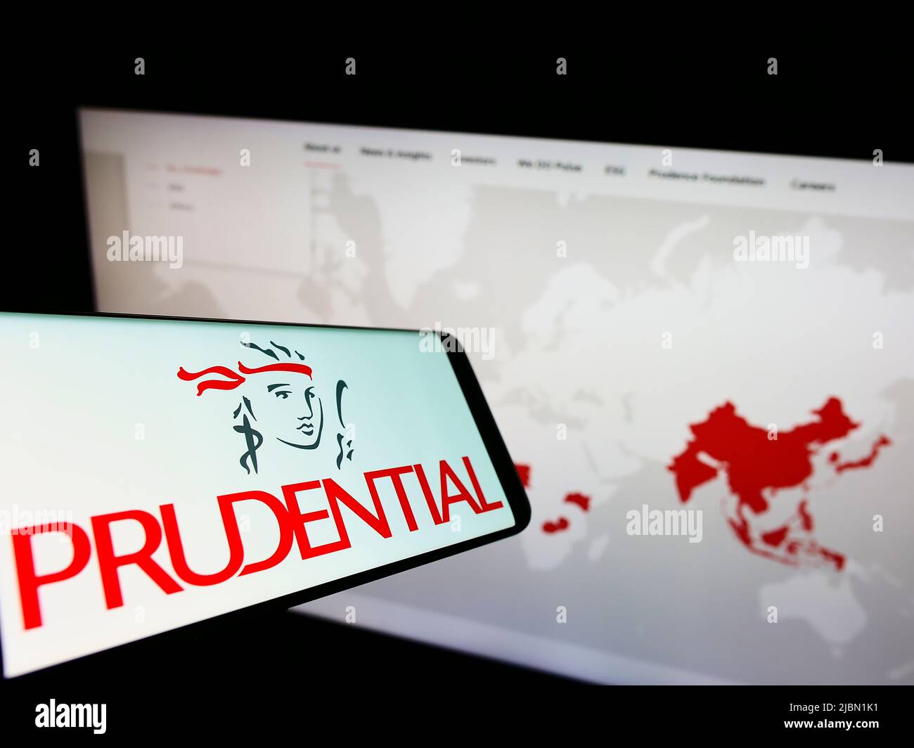 Téléphone mobile avec logo de la société de services financiers Prudential plc à l'écran devant le site Web de l'entreprise. Mise au point au centre-gauche de l'écran du téléphone. Banque D'Images