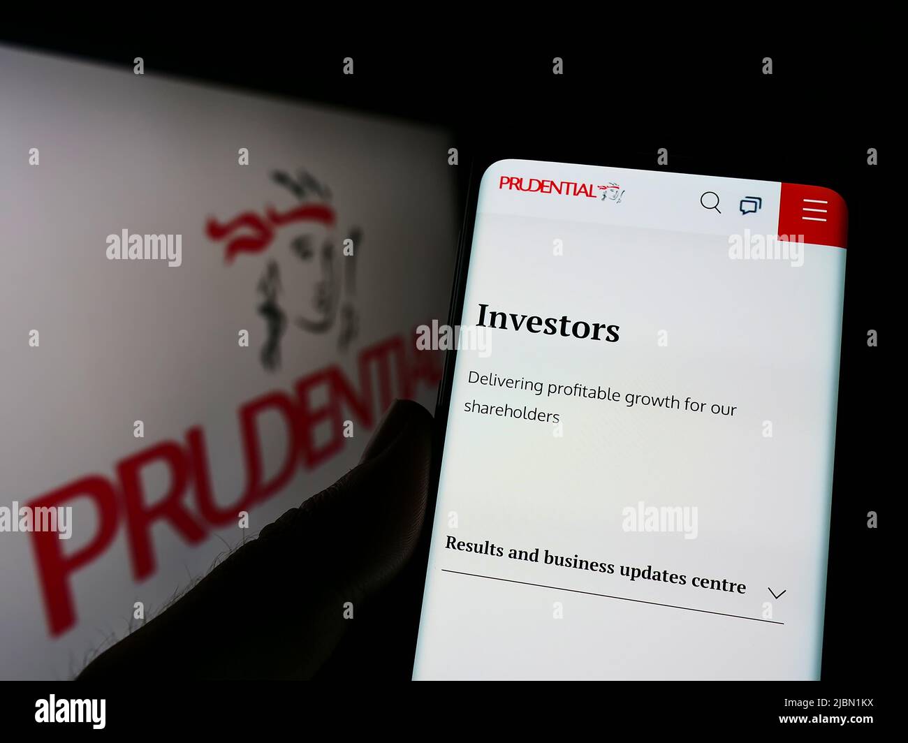 Personne tenant un téléphone portable avec la page Web de la société de services financiers Prudential plc à l'écran devant le logo. Concentrez-vous sur le centre de l'écran du téléphone. Banque D'Images