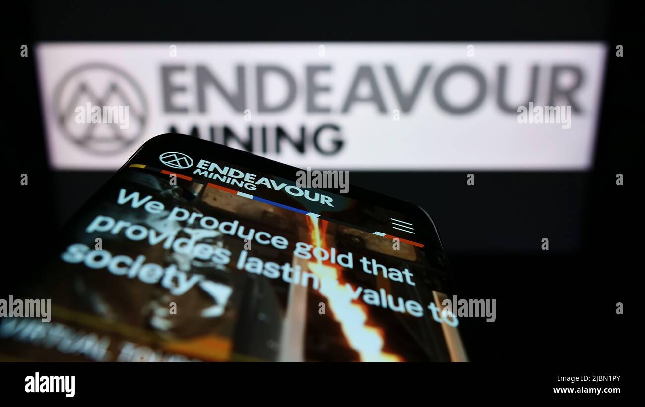Téléphone mobile avec site Internet de la société d'exploration aurifère Endeavour Mining plc à l'écran devant le logo. Faites la mise au point dans le coin supérieur gauche de l'écran du téléphone. Banque D'Images