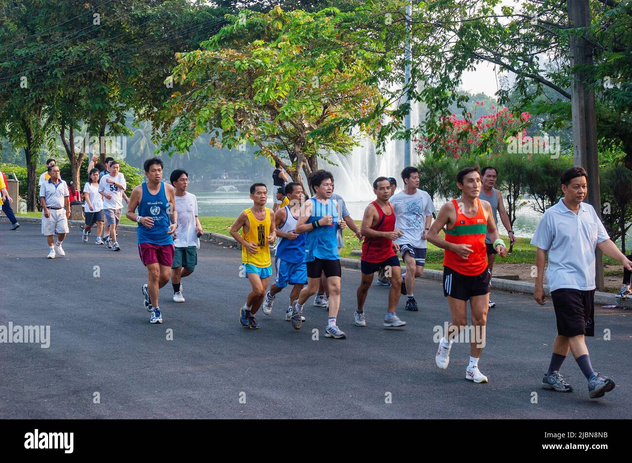 Promenade matinale et exercice d'étirement pour les aînés dans le parc Lumpini, Bangkok, Thaïlande Banque D'Images