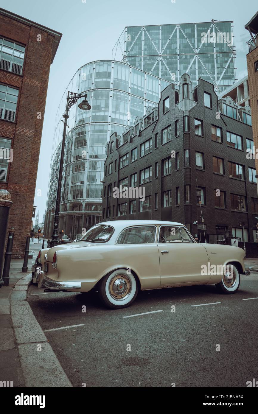 Une voiture classique garée devant quelques gratte-ciel. Banque D'Images