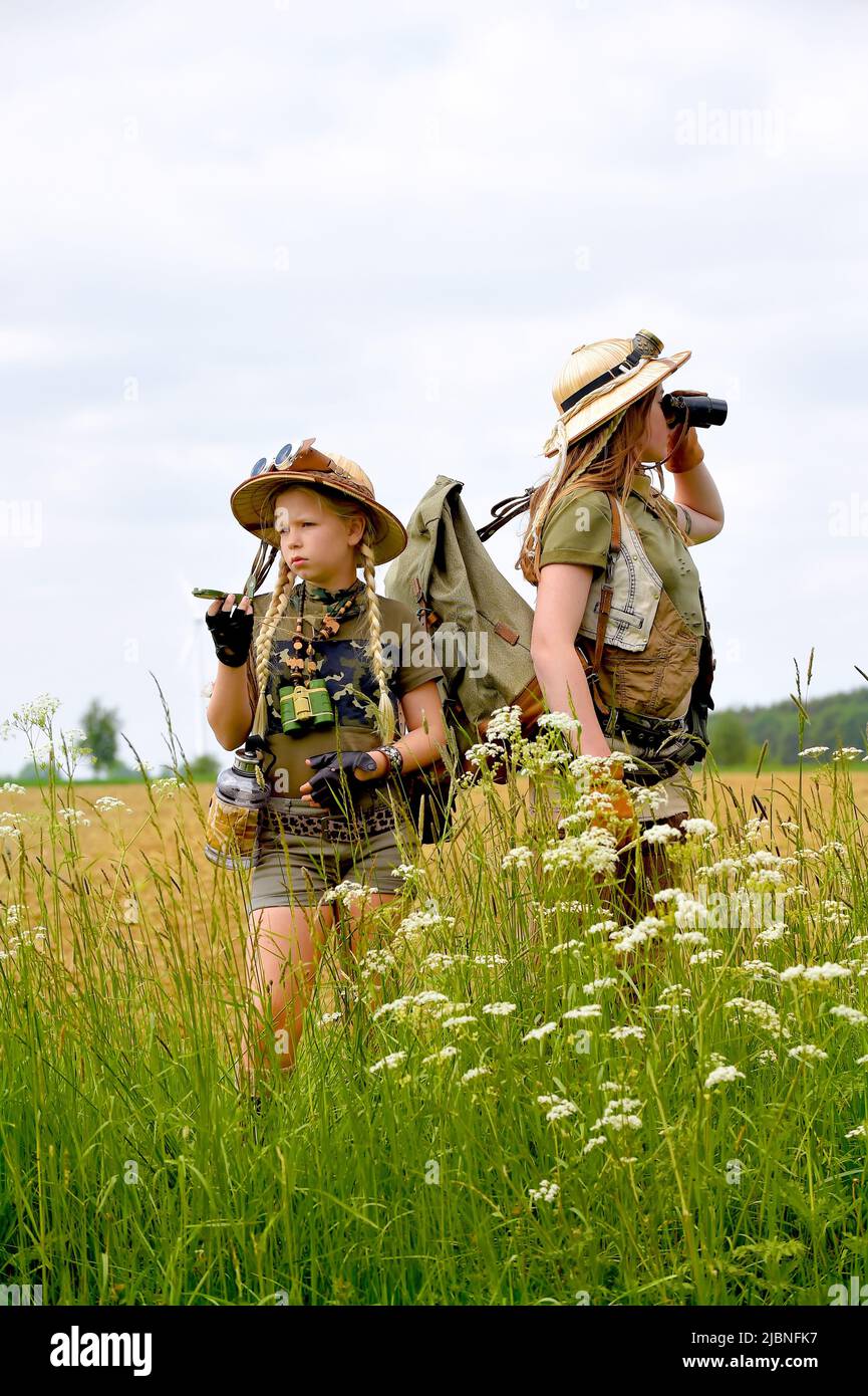 Deux jeunes filles sont vues sur un safari.ils observent la zone de  campagne extérieure. Ils sont habillés de chapeaux de safari, de jumelles  et d'oufi de safari kaki Photo Stock - Alamy