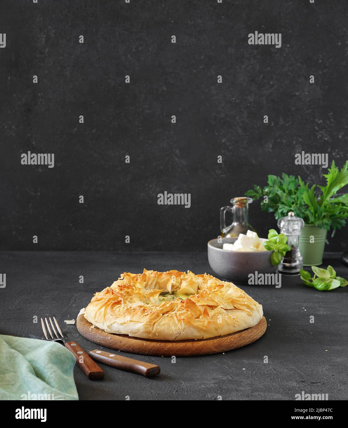 Cuisine grecque traditionnelle. Tarte à la Spanakopita aux épinards et au fromage feta sur fond sombre. Espace de copie Banque D'Images