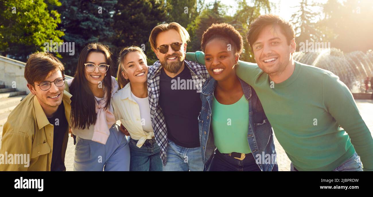 Portrait de groupe en plein air de jeunes amis multiraciaux souriants et enjoués Banque D'Images