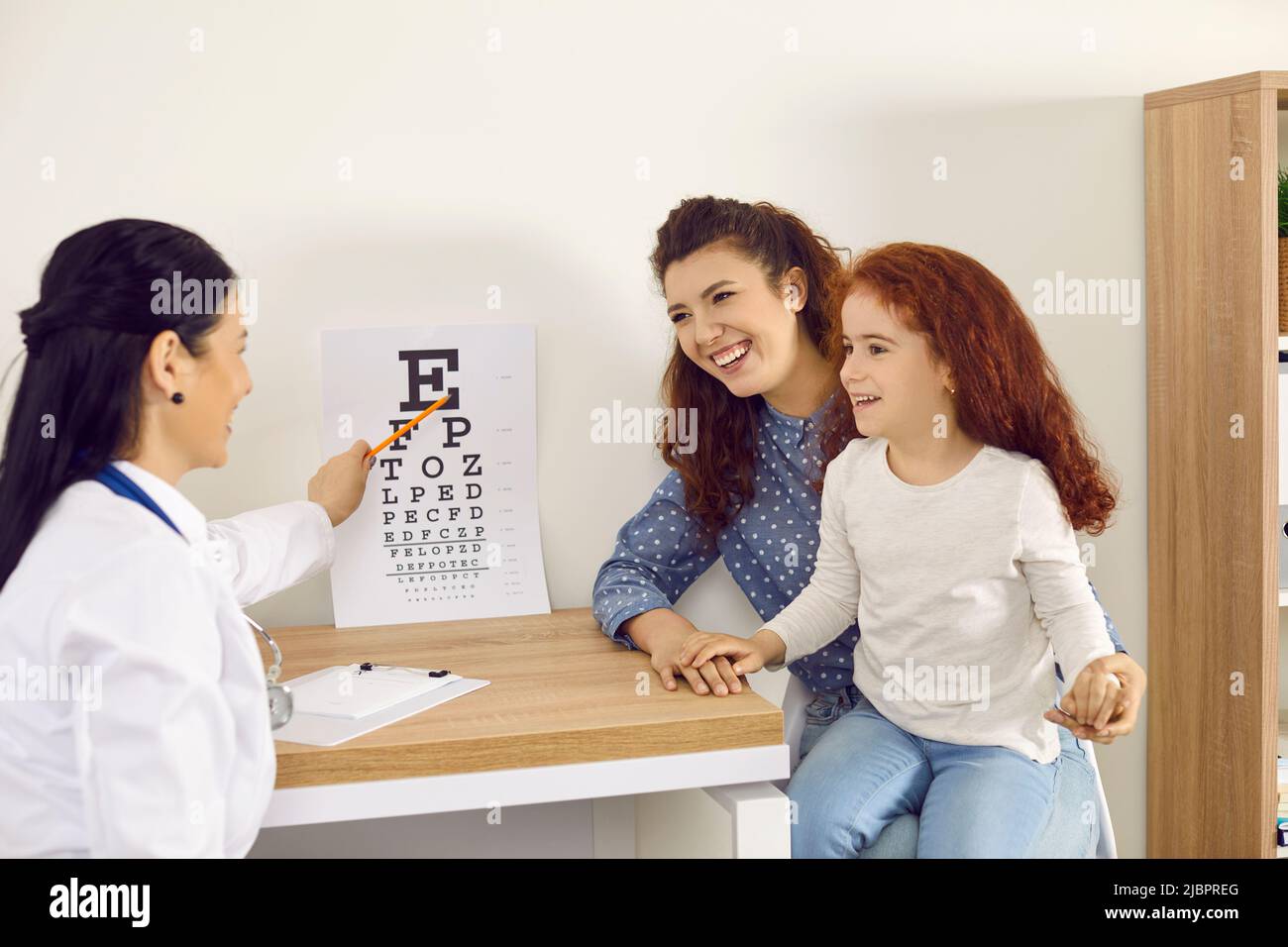 Une mère et un enfant heureux et joyeux viennent au bureau de l'ophtalmologiste pour l'examen de la vue Banque D'Images