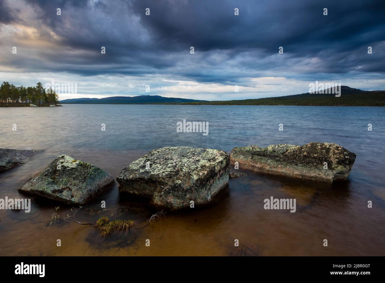 Grands rochers et ciel sombre et spectaculaire en soirée au lac Isteren, Engerdal kommune, Innlandet fylke, Norvège, Scandinavie. Banque D'Images