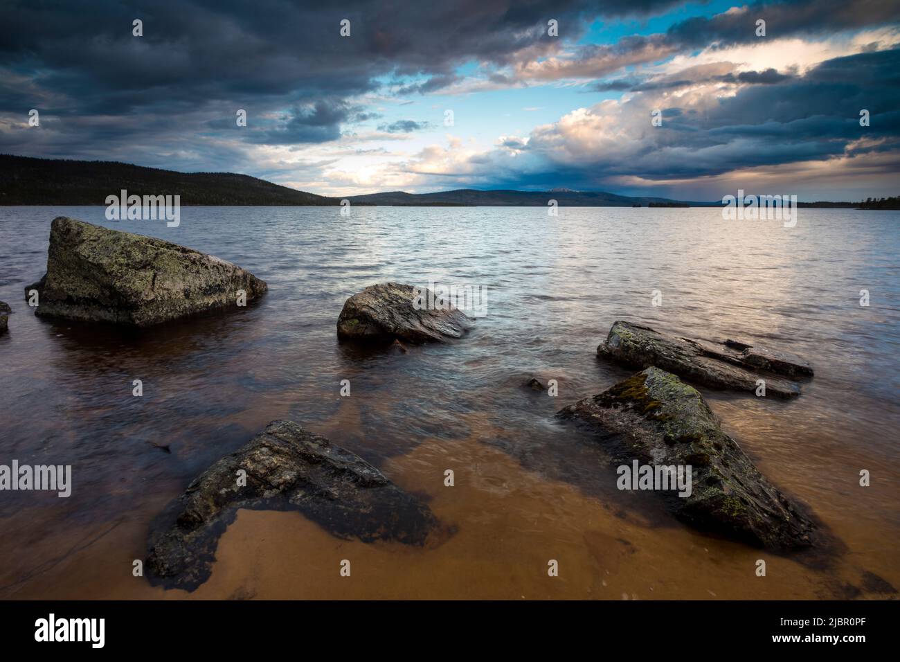 Grands rochers et ciel sombre et spectaculaire en soirée au lac Isteren, Engerdal kommune, Innlandet fylke, Norvège, Scandinavie. Banque D'Images