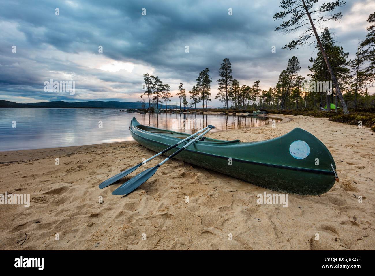 Faites du canoë sur une plage de sable en soirée d'été au bord du lac Isteren, Engerdal kommune, Innlandet fylke, Norvège, Scandinavie. Banque D'Images