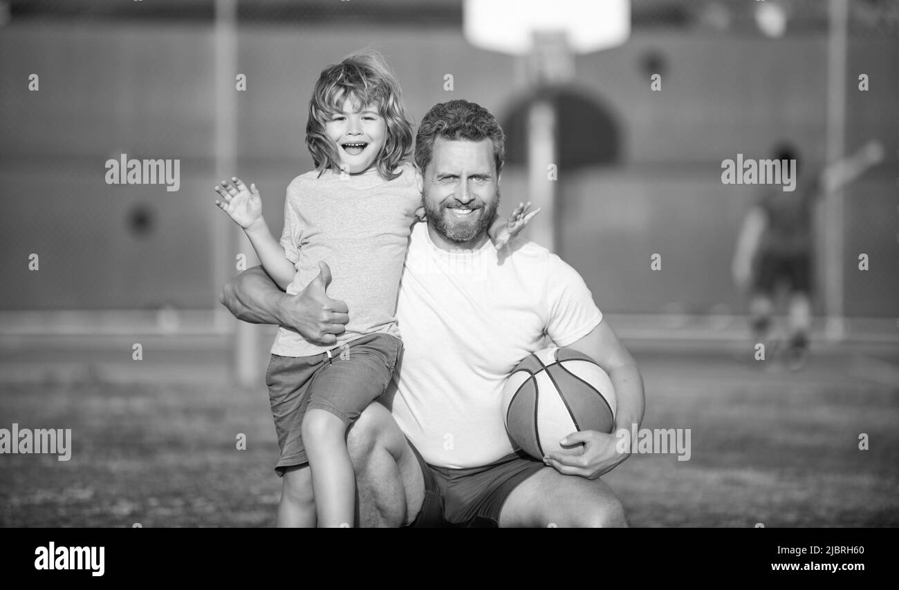 joyeux fête des pères. portrait de famille. papa et garçon d'enfant tiennent le ballon de sport. jeu d'enfant basket-ball. Banque D'Images