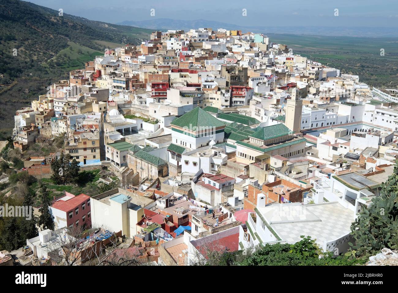 Vue sur les toits de tuiles vertes de la ville sainte de Moulay Idris, au Maroc, y compris le tombeau et Zawiya de Moulay Idriss, Moyen Atlas, Afrique du Nord. Banque D'Images